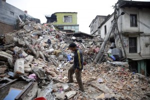 epaselect epa04720908 A man surveys the rubble of damaged building a day after a massive earthquake, in Kathmamdu, Nepal, 26 April 2015. More than 1,800 people were confirmed dead and many more were feared trapped under rubble Sunday in Nepal's worst earthquake in more than 80 years. The official death toll from the magnitude-7.9 earthquake reached 1,805, the Home Ministry said. One official said that figure could triple. Saturday's quake flattened buildings across the country and razed many historic landmarks. It was also felt in China, Bangladesh and India, where more than 40 deaths were reported. Buildings in the ancient centre of Kathmandu were destroyed, leaving mounds of timber and rubble, local television reported.  EPA/NARENDRA SHRESTHA